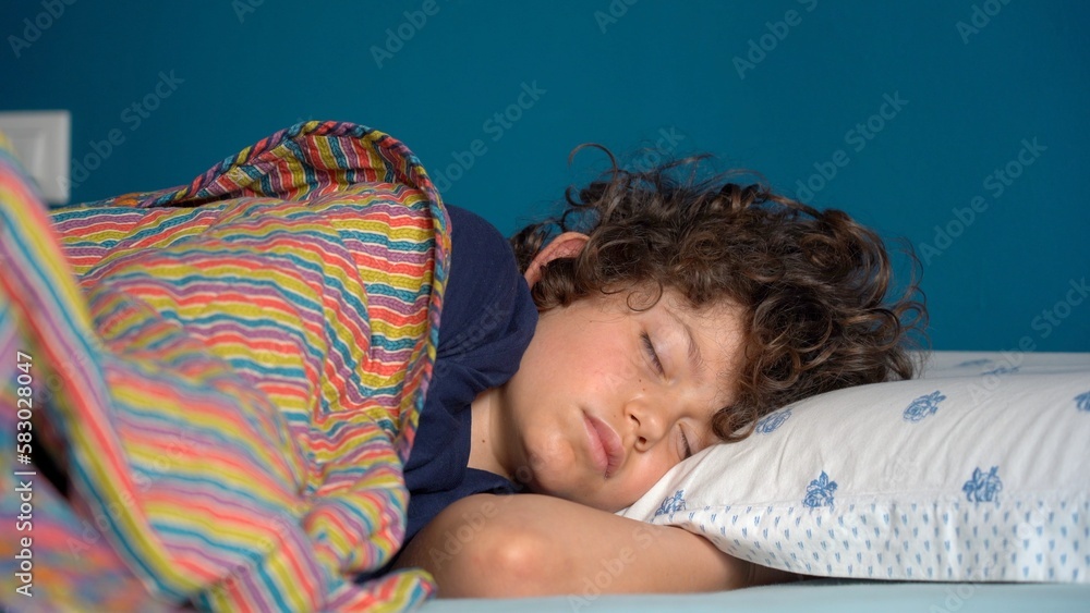 Boy child 8 years old sleeping at home in bedroom apartment - lifestyle in childhood - sleep in deep sleep and wake up to go to school and start the day