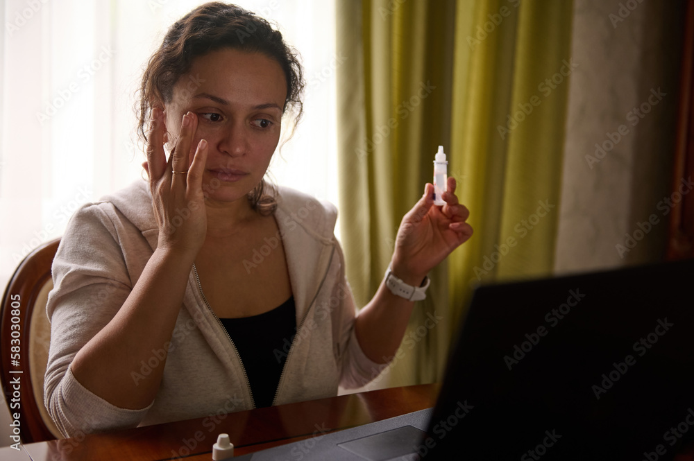 Female entrepreneur freelancer working on laptop and holding medicinal