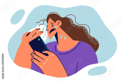 Crying woman wipes tears with handkerchief and holds phone while watching melodrama film