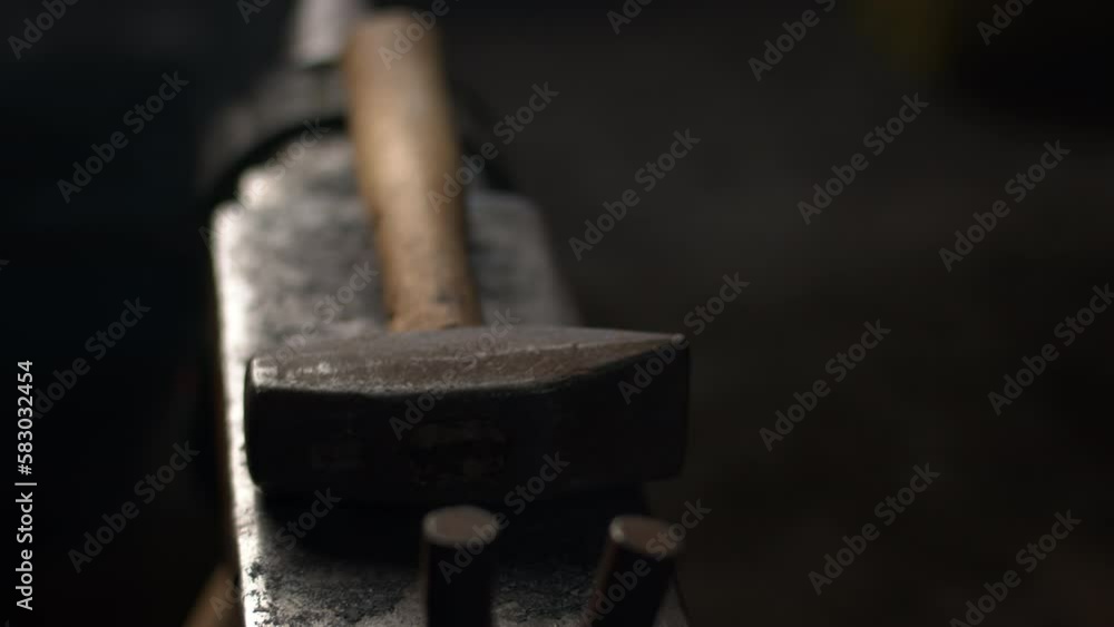 A hammer sits on an anvil in a blacksmiths workshop A hammer sits on an anvil in a blacksmiths workshop