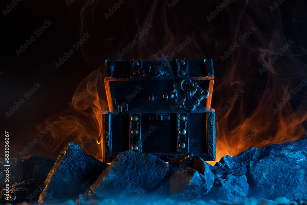 Mystical chest and key on fire on the rocks. Fantastic and fabulous ...