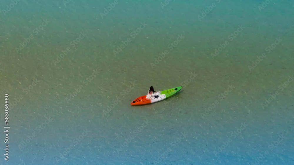 Aerial view of woman traveller exploring calm tropical bay ,Travel and Active Lifestyle concept