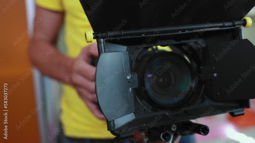 Cameraman operator holds cinema camera in hands, lens with matte box