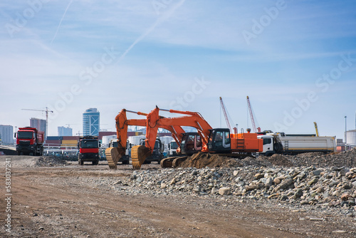 Excavators or diggers with dumper trucks on construction site or earthmoving at shore protection works in Batumi. photo