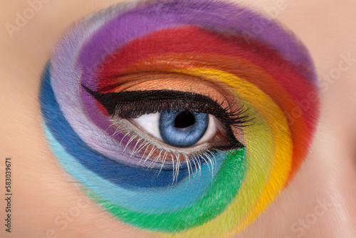 Fashion concept make up of spinning rainbow. Close up eye with artistic rainbow make up. Colors and colorful. Joy. Artistic and fashion make up. Cosmetics. On stage make up