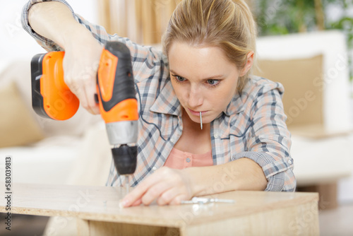 woman in plaid shirt t-shirt working in carpentry workshop photo