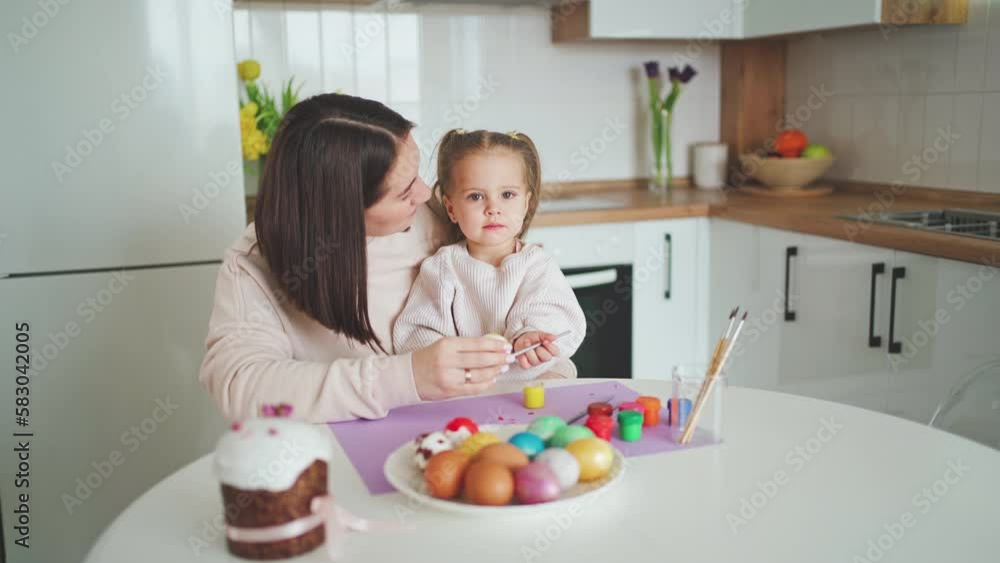 Happy Easter Holiday. Beautiful mother and daughter paint and decorate an egg Happy Easter Holiday. Beautiful mother and daughter paint and decorate an egg
