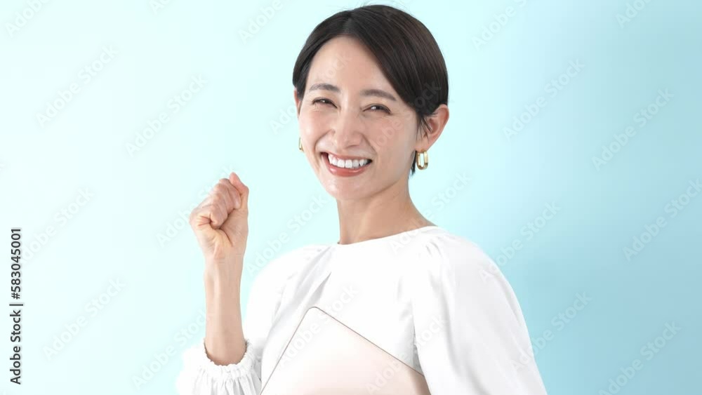 パソコンを持ちガッツポーズをする日本人女性 パソコンを持ちガッツポーズをする日本人女性