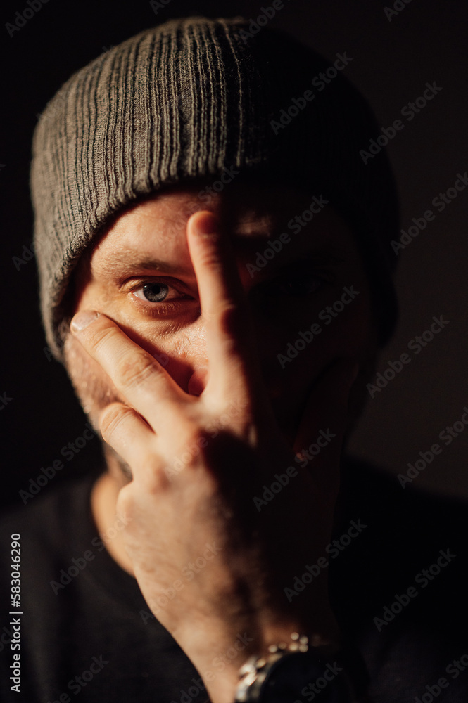 Serious dramatic man looking away while standing against black studio background Serious dramatic man looking away while standing against black studio background