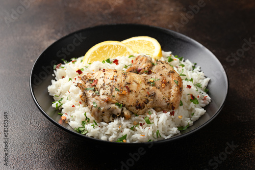 Grilled Chicken thighs served with rice in a black bowl