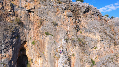 Rock climbers climbing on the cliff. Aerial view from drone. People, mountaineering, adventure concept.