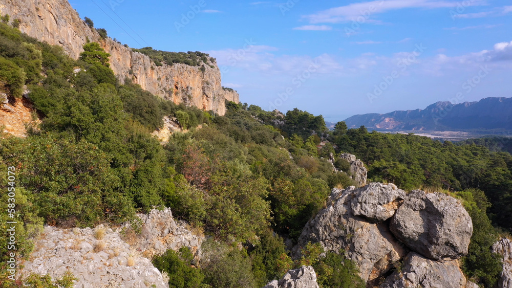 Aerial view of huge rocky formations on a forested mountains slopes. Nature landscape. Aerial view of huge rocky formations on a forested mountains slopes. Nature landscape.