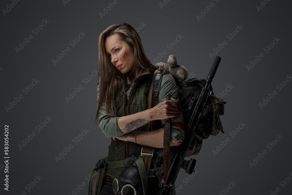 Studio shot of desperate murderer woman with knife against grey background. Studio shot of desperate murderer woman with knife against grey background.