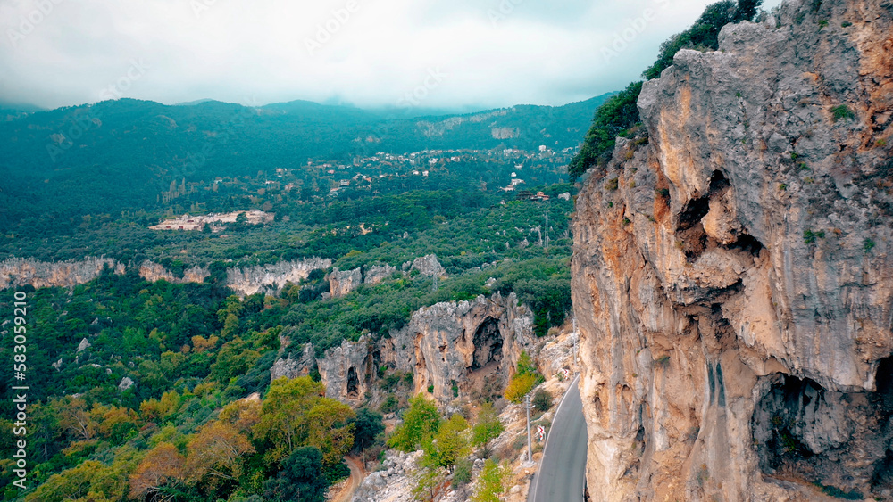 Aerial panoramic view of road along rocky mountain. Wild nature landscape from above.