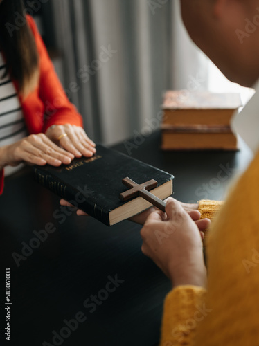 Woman s hand with cross .Concept of hope  faith  christianity  religion  church and pray to God. on the black table..