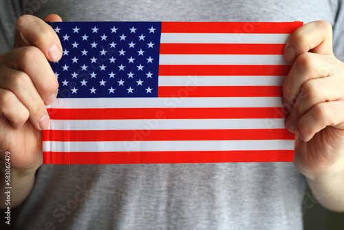 US flag in human hands, close-up photo.