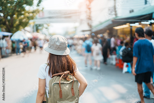 woman traveler visiting in Bangkok, Tourist with backpack and hat sightseeing in Chatuchak Weekend Market, landmark and popular attractions in Bangkok, Thailand. Travel in Southeast Asia concept
