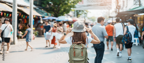 woman traveler visiting in Bangkok, Tourist with backpack and hat sightseeing in Chatuchak Weekend Market, landmark and popular attractions in Bangkok, Thailand. Travel in Southeast Asia concept