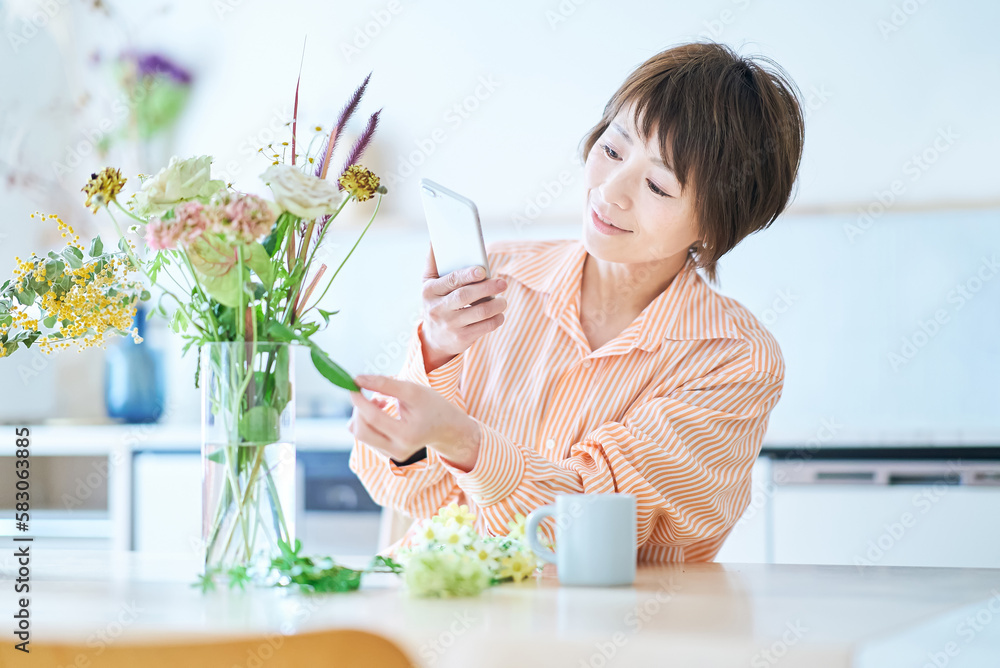 部屋で花を生ける女性