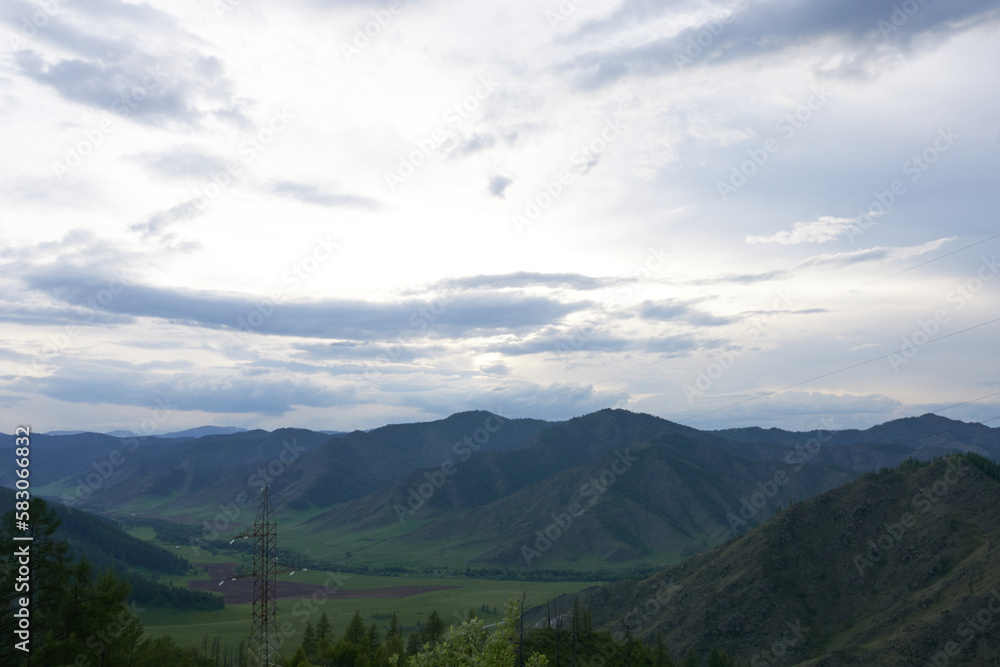 Panoramic view of the mountains in the evening in variable weather. The Altai Mountains.
