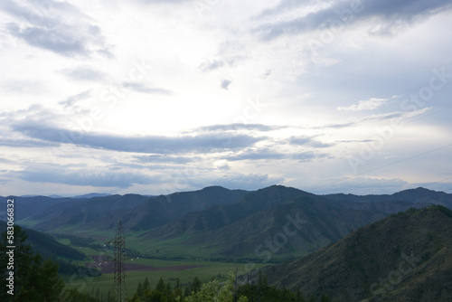 Panoramic view of the mountains in the evening in variable weather. The Altai Mountains. 