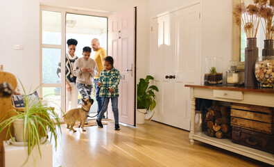 Family arriving home, boy with Down syndrome with dog