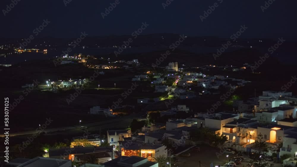Panoramic view of Plaka village with traditional Greek church and ocean coast in the night. Milos island, Greece Panoramic view of Plaka village with traditional Greek church and ocean coast in the night. Milos island, Greece