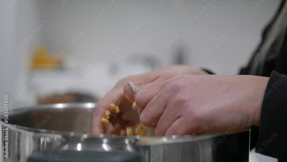 Closeup of woman's hands while cutting trahana pieces into a large pot. Cooking traditional Greek Cypriot soup. Closeup of woman's hands while cutting trahana pieces into a large pot. Cooking traditional Greek Cypriot soup.