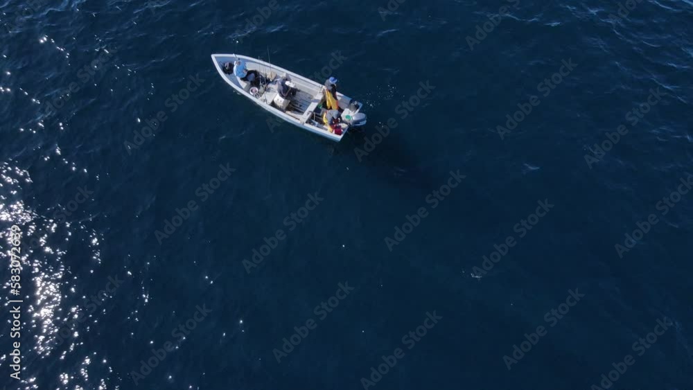 Descending aerial over fishermen on boat in deep blue open ocean Descending aerial over fishermen on boat in deep blue open ocean