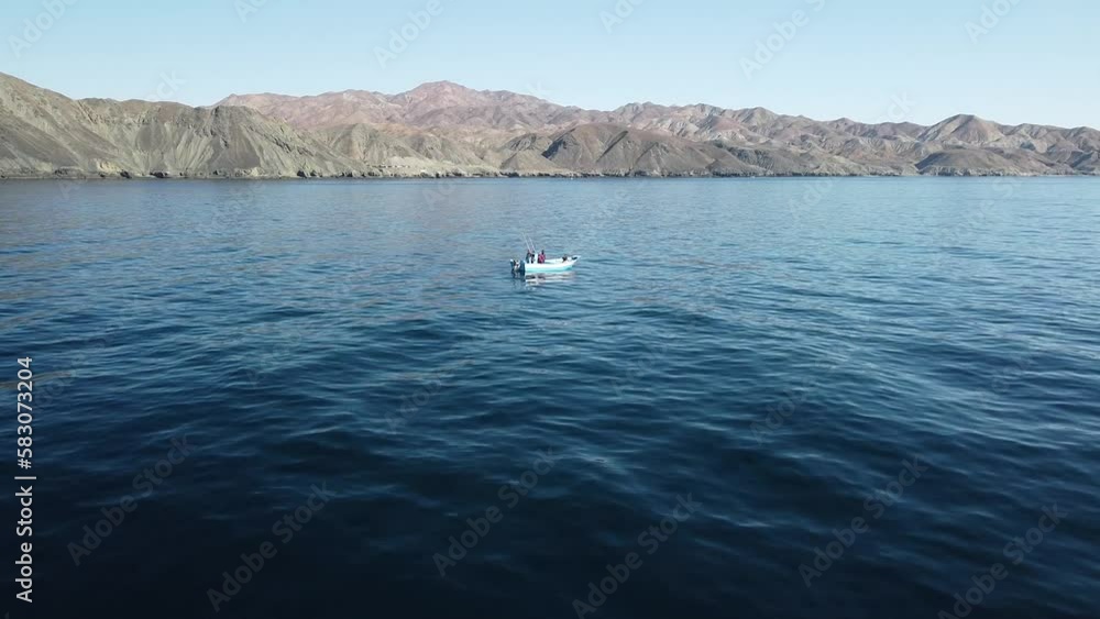 Aerial dolly over fishermen prepping lines, rods, and reels with coast background Aerial dolly over fishermen prepping lines, rods, and reels with coast background