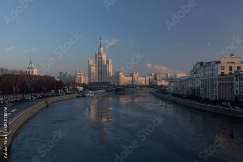 Stalinist architecture of the Soviet era. Tourist attraction. Skyscraper in Stalin's Empire style. High-rise building on Kotelnicheskaya embankment at sunset. City ​​landmark of Moscow.