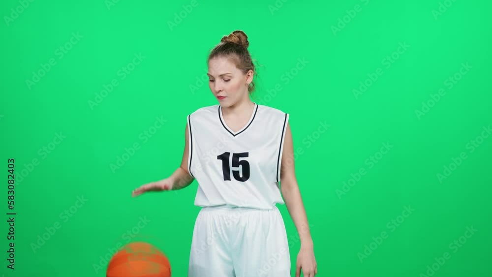 Pretty sporty woman on a chromakey, basketball player throw the ball in his hands, professional basketball player in an indoor playground, green background. Pretty sporty woman on a chromakey, basketball player throw the ball in his hands, professional basketball player in an indoor playground, green background.