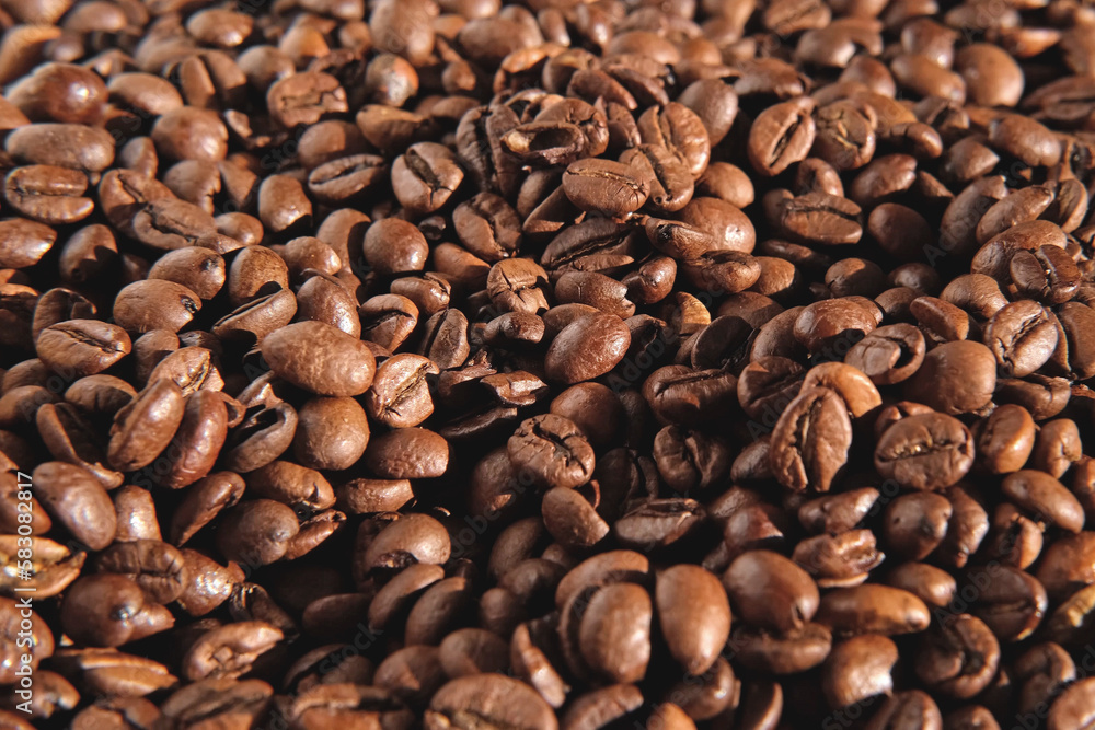 Obraz premium Coffee beans background. Texture of coffee beans close up. Dark brown roasted coffee is spinning. Abundance. Concept for coffee product advertising. Selective Focus. Border design with copy space