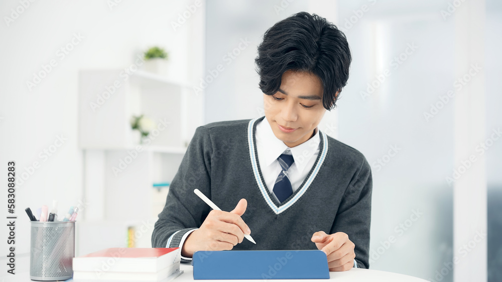 タブレットで勉強する男子学生