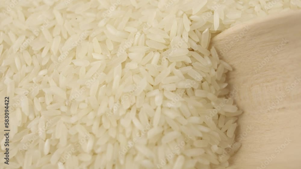 grains of white rice are collected in a wooden spoon culinary background kitchen sushi grains of white rice are collected in a wooden spoon culinary background kitchen sushi