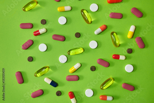 Its like an optical illusion. Studio shot of an assortment of medication against a green background.