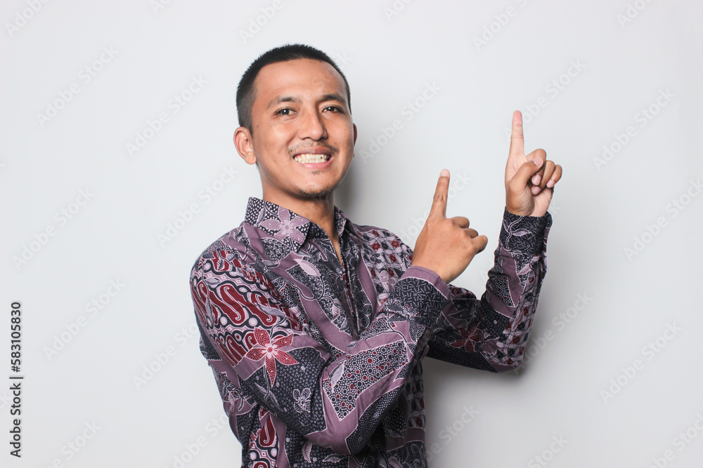 Asian young man poiting up at the copy space above his, isolated on white background. Asian young man poiting up at the copy space above his, isolated on white background.