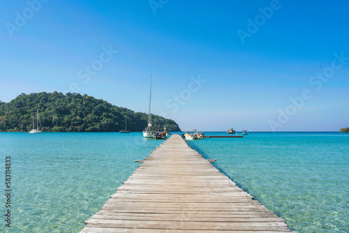 Scenery of wooden pier in tropical sea and sightseeing boat in sunny day on summer