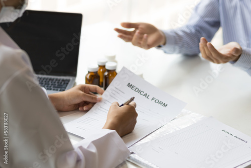 Male patient talks about his illness to the doctor. The doctor gives treatment advice to the patient in the hospital examination room. Treatment of disease by medicine from a specialized doctor.