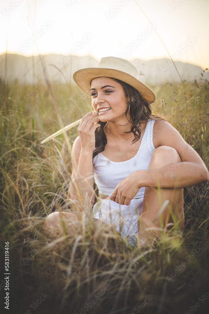 Young Woman Enjoying a Serene Moment in a Field of Long Grass