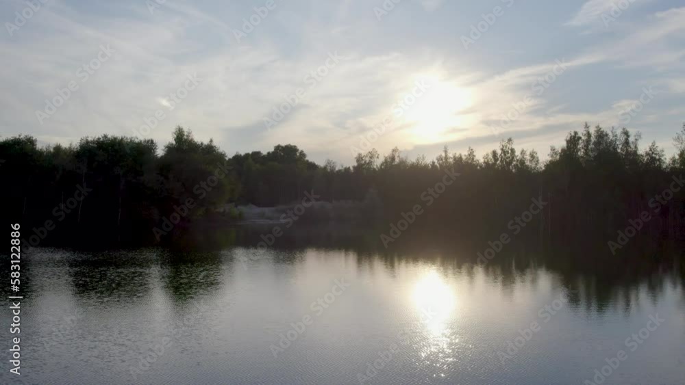 Drone flies over lake and trees on a clouded sunset in autumn in Belgium with the sky reflected on the water. High quality 4k footage Drone flies over lake and trees on a clouded sunset in autumn in Belgium with the sky reflected on the water. High quality 4k footage