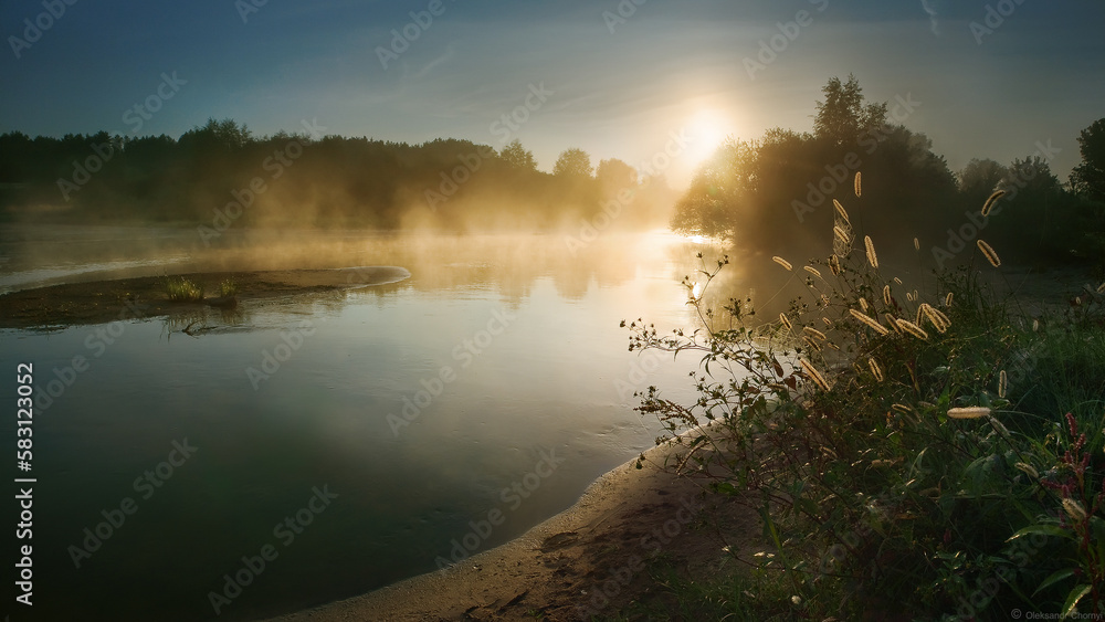 Golden sunrise. Foggy morning nature landscape. Picturesque summer background. Bright sun on the river. Beautiful sunlight on the river bank. Amazing sunrise.