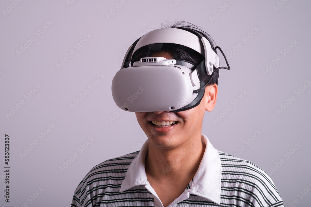 Surprised teen male student use vr glasses and looks at empty space with gray background. Virtual gadgets for entertainment, work, free time and study. Virtual reality metaverse technology concept. Surprised teen male student use vr glasses and looks at empty space with gray background. Virtual gadgets for entertainment, work, free time and study. Virtual reality metaverse technology concept.