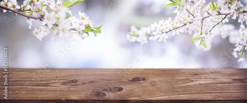 Empty wooden counter for product presentation with cherry blossoms. Horizontal spring background for seasonal decorations and space for text. © gudrun