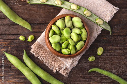 Broad bean or fava beans (Fave)  on the rustic wooden background, close-up. From garden to table:
 springtime vegetables and legumes for spring recipes