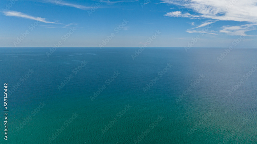 Aerial view of blue ocean with waves and blue skies with clouds. Seascape in the tropics. Borneo, Malaysia.
