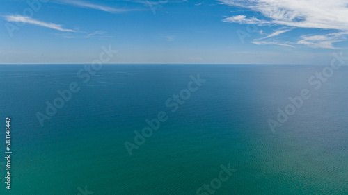 Aerial view of blue ocean with waves and blue skies with clouds. Seascape in the tropics. Borneo, Malaysia.