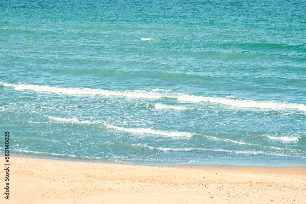 Obraz premium Transparent waves run into the sandy beach. Crystal clear water on the beach. Ecologically clean place for a carefree summer holiday.