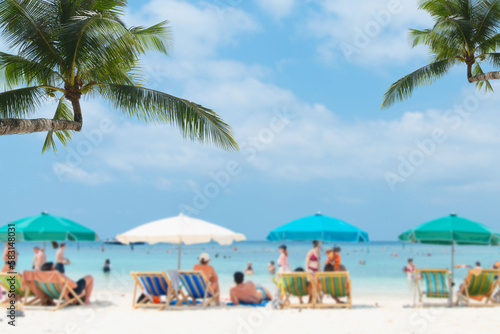 Fototapeta Naklejka Na Ścianę i Meble -  Beach in the blurred foreground with people and a blue sky in the background. Travelers who appreciate the vacation are unwinding on the beach during the island's summer