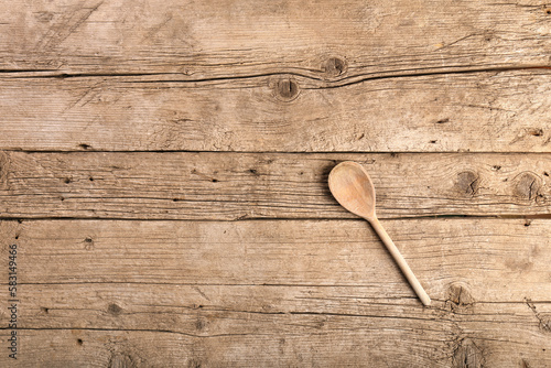 Wooden spoon on a wooden background top view copy space.